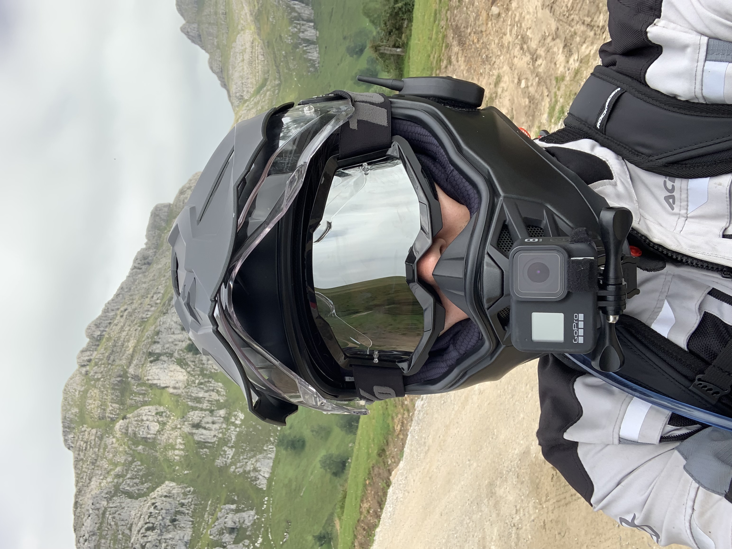 Scorpion ADF-9000 worn on a mountain track, with goggles and a GoPro
